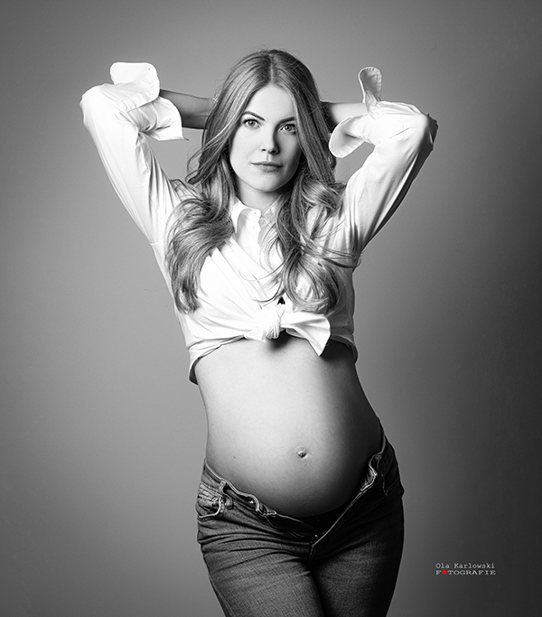 Schwangerschaftsfotografie Düsseldorf. Schwangere mit Armen hinter dem Kopf verschränkt. Freier Schwangerschaftsbauch. Fotografin A. Ola Karlowski. Babybauchfotografie Düsseldorf.