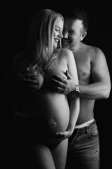 Intime Partner-Schwangerschaftsfotografie in Düsseldorf: schwarz-weiß Studioaufnahme eines werdenden Paares mit Fokus auf Nähe, Babybauch und Emotion.
