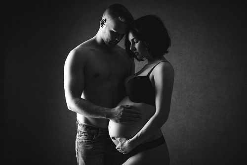 Schwarz-weiß Partner-Babybauchfotografie in Düsseldorf: inniges Studio-Portrait eines werdenden Paares mit ruhiger Lichtführung