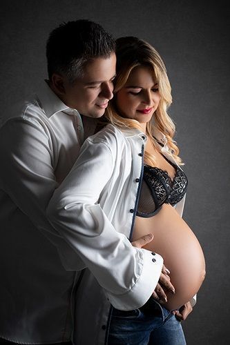 Elegantes Babybauchfoto mit Partner in Düsseldorf: werdende Eltern in ruhiger, schützender Pose.