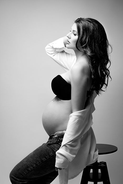 Schwarz-weiß Schwangerschaftsfotografie in Düsseldorf: elegante Studioaufnahme einer schwangeren Frau im Profil mit weichem Licht.
