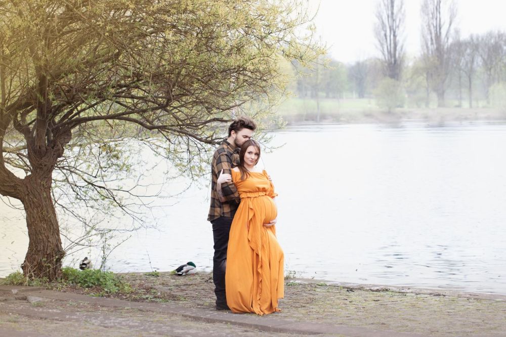Outdoor Babybauchporträt bei natürlichem Licht in Düsseldorf: Fokus auf Emotion und natürliche Form.